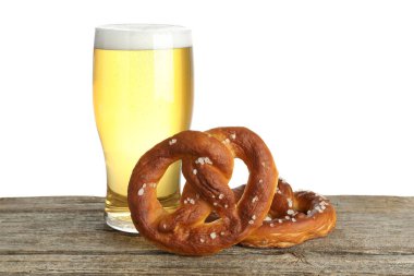 Lezzetli krakerler ve beyaz arka plana karşı ahşap masada bir bardak bira.