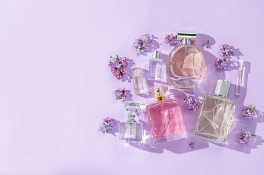 Lüks parfümler ve açık mor arka planda güzel leylak çiçekleri. Metin için boşluk