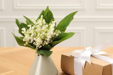 Vadi çiçeklerinin güzel zambakları ve hediye ahşap masada, yakın plan.