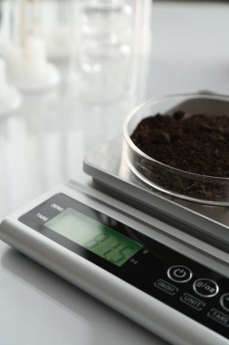 Beyaz ayna masasındaki Petri kabıyla ölçeklendir, yakın plan.