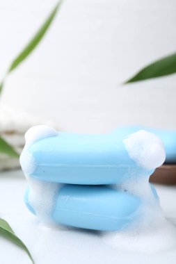 Beyaz masadaki köpüklü sabun çubukları, yakın plan.