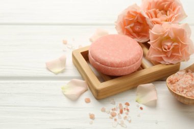 Sabun barı, deniz tuzu ve beyaz ahşap masada güzel çiçekler, yakın plan. Metin için boşluk