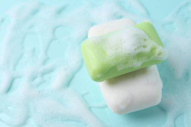 Açık mavi arka planda köpüklü sabun çubukları. Metin için boşluk