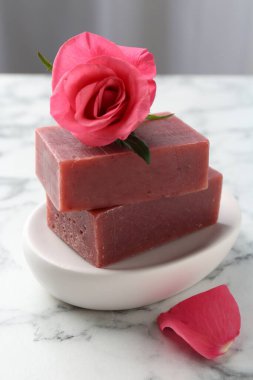 Sabun çubukları ve beyaz mermer masada güzel bir gül, yakın plan.