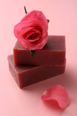 Sabun çubukları ve pembe arka planda güzel bir gül, yakın plan.