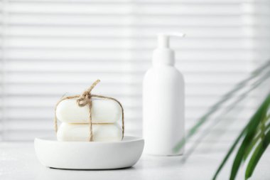 Beyaz masadaki sabun çubukları ve şişe kapalı, seçici odak