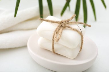 Beyaz masadaki sabun çubukları ve havlular, yakın plan.