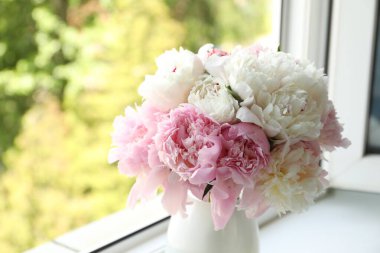 Pencere kenarındaki vazoda güzel şakayıklar, yakın plan.