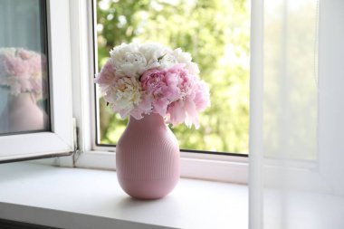 Pencere kenarındaki vazoda güzel şakayıklar