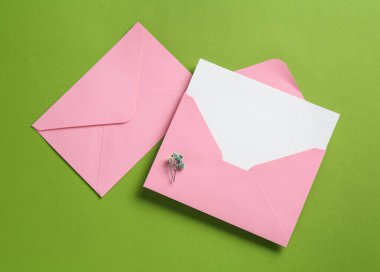 Boş davetiye kartı ve yeşil arka planda zarflar. Tasarım için boşluk