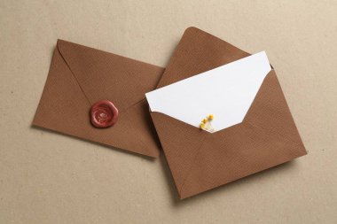 Kutusunda çiçekler ve zarflar olan boş davetiye kartı, düz konum