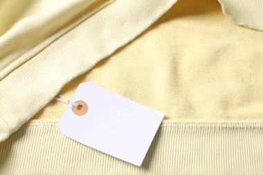 Karton etiketli bej giysi, üst görünüm