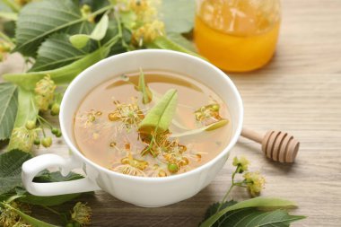 Taze ıhlamur çayı, bal ve çiçekler ahşap masada, yakın plan.