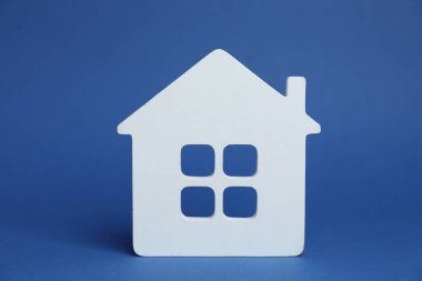 Mavi arka planda bir beyaz ev modeli