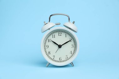 Açık mavi arkaplanda bir beyaz alarm saati