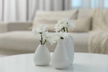 Güzel kasımpatı çiçekleri vazoların içinde, beyaz masa içinde, yakın plan