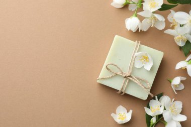 Açık kahverengi arka planda sabun ve yasemin çiçekleri. Metin için boşluk