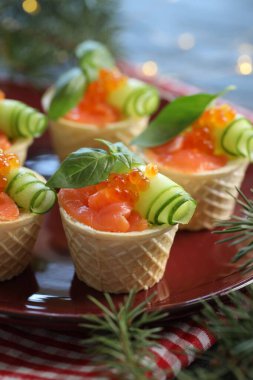 Lezzetli kanepeler ve köknar dalları masada, yakın plan.