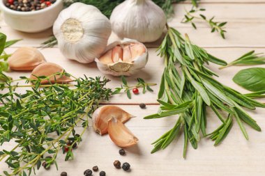 Beyaz ahşap masada farklı taze otlar ve baharatlar, yakın plan.
