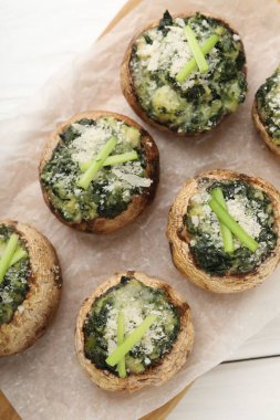 Beyaz ahşap masada servis edilen lezzetli mantarlar.