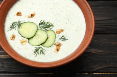 Ahşap masada dereotlu ve cevizli lezzetli salatalık çorbası, yakın plan.