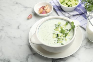 Dereotlu salatalık çorbası, mikro yeşiller ve beyaz mermer masa üzerindeki malzemeler, yakın plan.