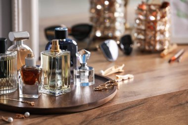 Ahşap masada farklı parfüm ve aksesuar şişeleri, yakın plan. Metin için boşluk