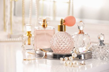 İçerideki tuvalet masasında farklı parfüm ve aksesuar şişeleri, yakın plan.
