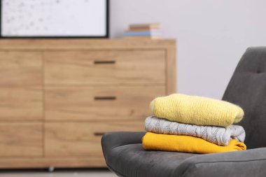 İçerideki koltukta yün süveter yığını, metin için yer