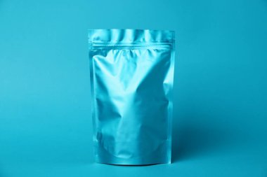 Açık mavi arka planda fermuarlı bir stand-up kesesi. Tasarım için model