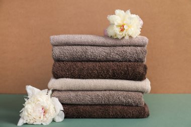 Renkli arka planda yumuşak havlu ve şakayık çiçekleri yığını