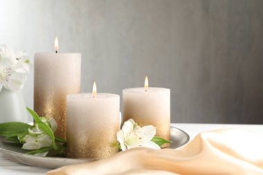 Beyaz masada yanan mumlar ve güzel çiçekler. Metin için boşluk