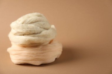 Kahverengi arka planda doğal keçeli yün, yakın plan. Metin için boşluk