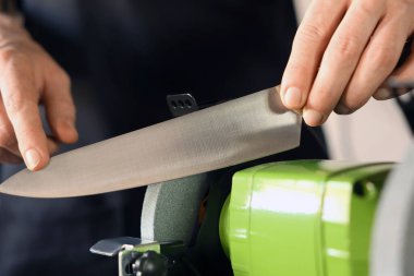 Bıçak keskinleştiren adam içeride, yakın plan.