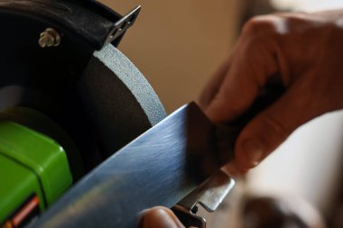 Bıçak keskinleştiren adam içeride, yakın plan.