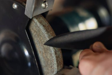 Bıçak keskinleştiren adam içeride, yakın plan.