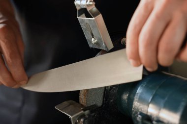 Bıçak keskinleştiren adam içeride, yakın plan.