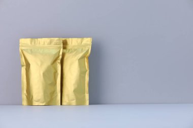 Açık gri arka planda iki fermuarlı stand-up kesesi. Tasarım için model