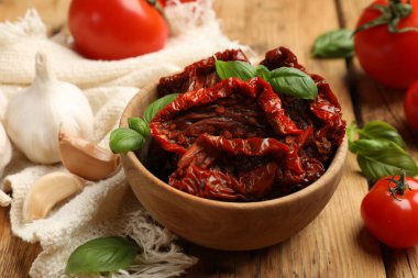 Lezzetli, kurutulmuş domatesler ve taze sebzeler ahşap masada, yakın plan.