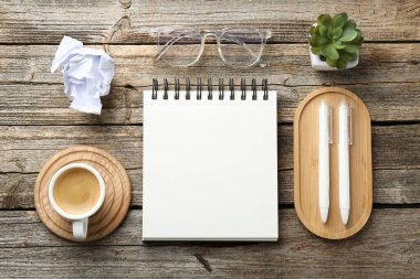 Düz kompozisyon, tahta masanın üzerinde boş bir defter.