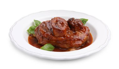 Geleneksel ossobuco yemeği biftek, sos ve fesleğen beyaza izole edilmiş.