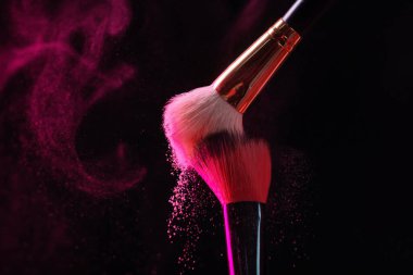 Siyah arka planda pembe göz farlı makyaj fırçaları, yakın plan