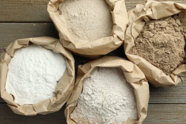 Tahta masadaki kağıt torbalarda farklı türde un var.