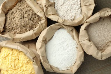 Tahta masadaki kağıt torbalarda farklı türde un var.
