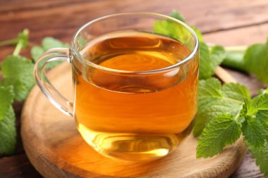 Cam bardakta Aromatik limon merhemi çayı ve masada taze yapraklar, yakın plan.