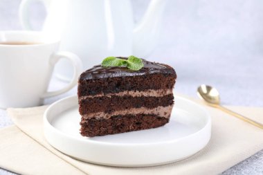 Gri masadaki naneli ve kaşıklı lezzetli çikolatalı pasta.