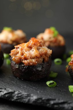 Siyah masada servis edilen lezzetli mantarlar bulanık arka plan, yakın plan