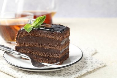 Nane, çatal ve çayla servis edilen bir parça çikolatalı kek, yakın plan. Metin için boşluk