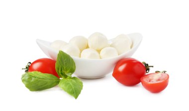 Beyaz arka planda lezzetli mozzarella peynir topları, domates ve fesleğen.