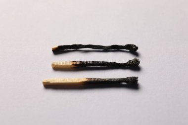 Gri arkaplanda yanmış kibritler, yakın plan görünümü